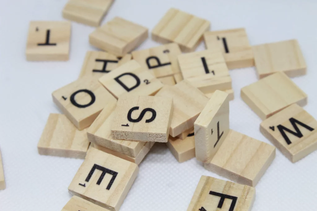 A pile of Scrabble pieces on a white surface.