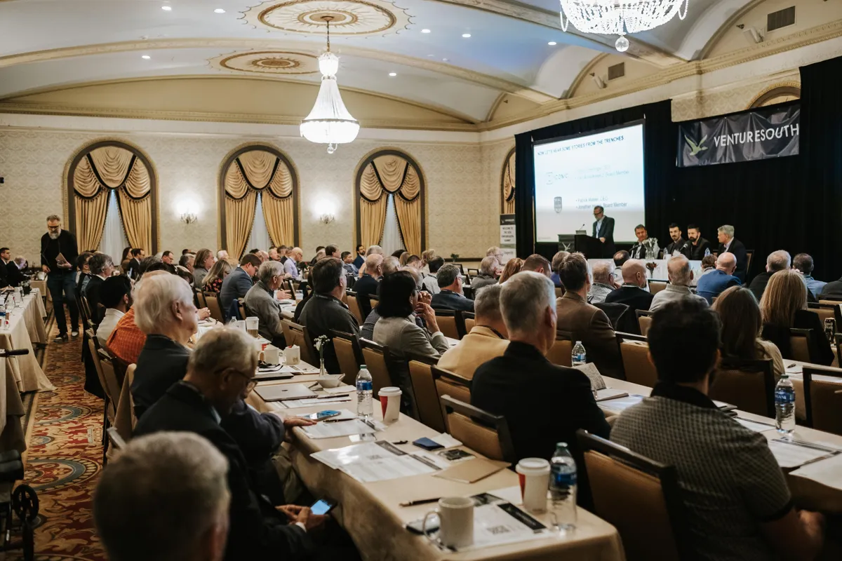Investors at a VentureSouth event with a speaker on stage